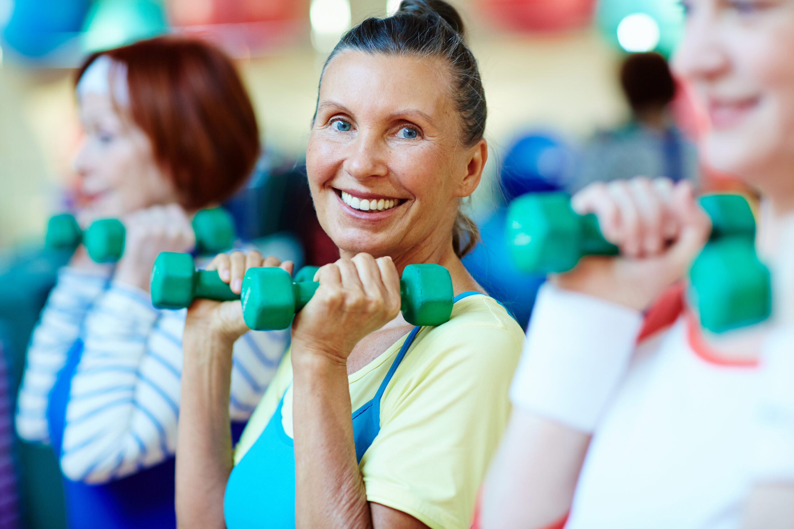 Osteobusters senior fitness class participants with a lady that is a leader smiling 